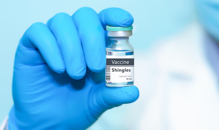 Doctor in protective gloves holding a shingles vaccine.